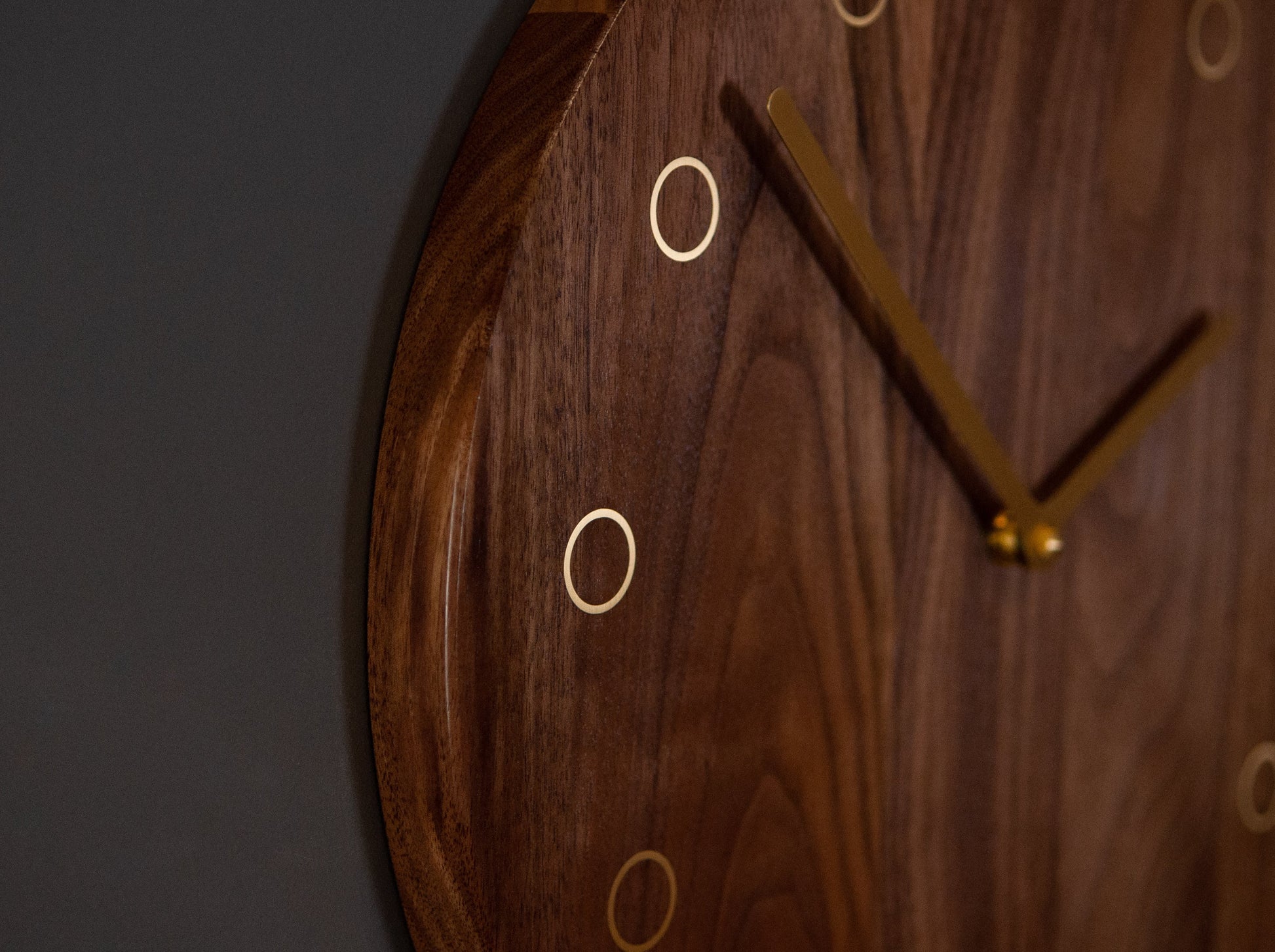 hickory wooden clock close up of brass clock hands and accents